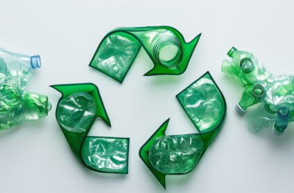 Conceptual image of a recycle symbol formed with crushed transparent plastic bottles highlighting eco friendliness